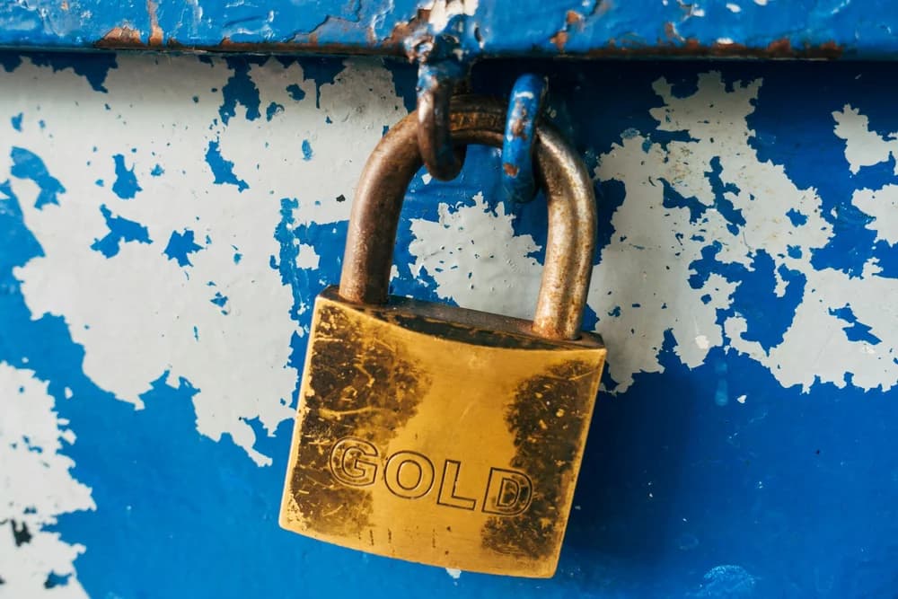 Golden padlock on a weathered blue surface