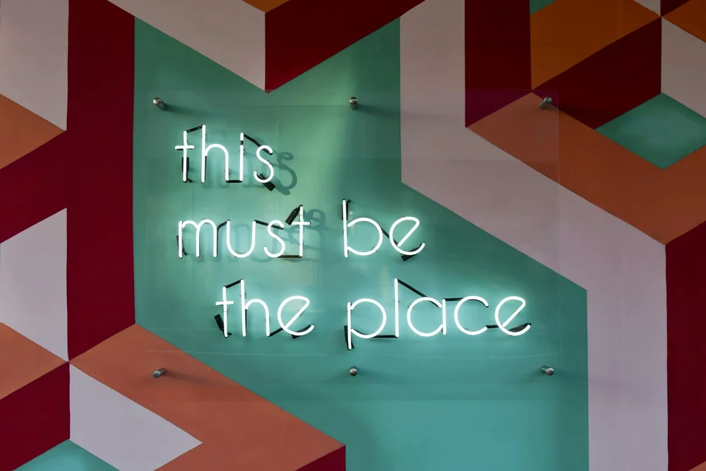 Neon sign reading “this must be the place”